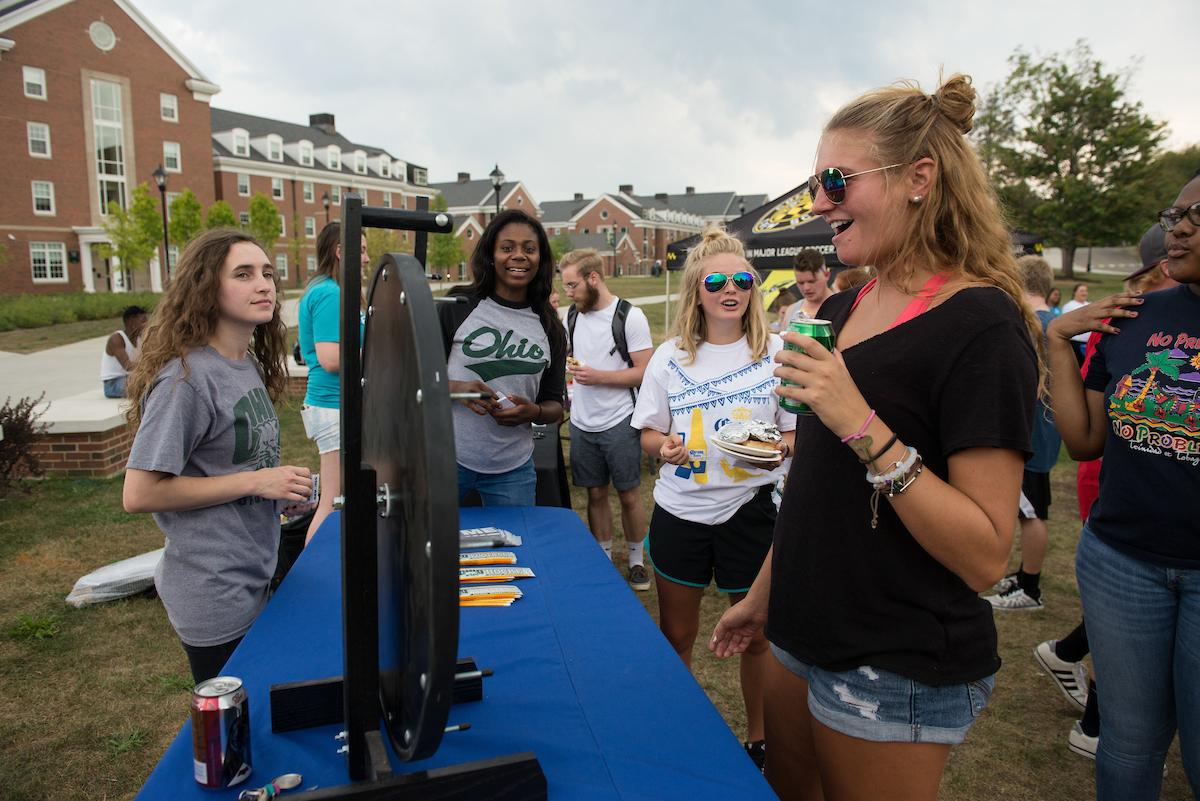 students standing around a table and spinning a wheel at the South Beach Bash event