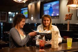 Two girls enjoy dinner together at Latitude 39's bar