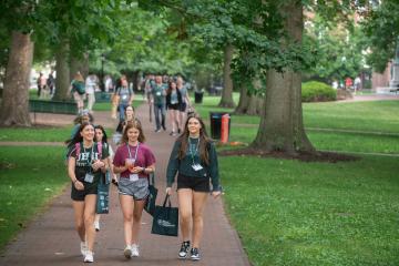 OHIO students taking part in Bobcat Student Orientation walk in a group on the College Green