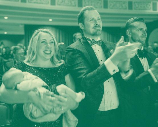 Two people applauding at alumni awards event