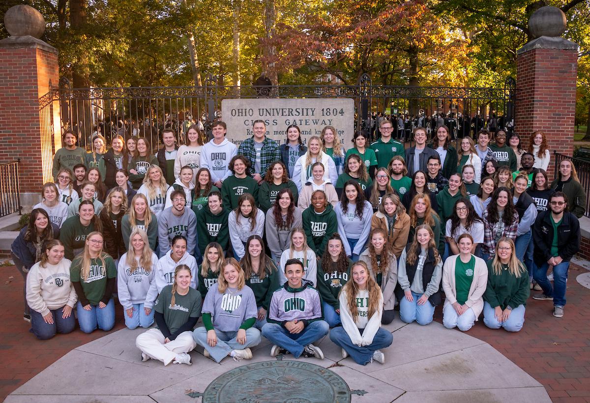 2024-2025 Tour Guides posing in front of the college gate.